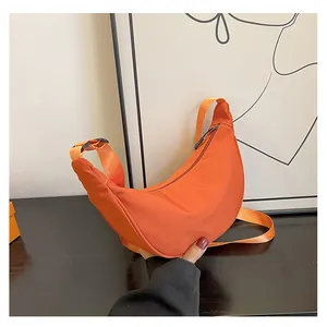 Dettaglio della borsa a tracolla arancione in nylon a mezzaluna con tracolla regolabile