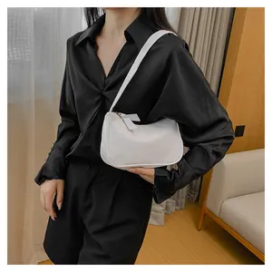 Minimalistische weiße Hobo-Tasche aus Leder, getragen von einem Modell in Schwarz