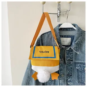 Detail of cute yellow canvas duck bag with plush tail and webbed feet on denim jacket