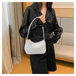 Minimalistische weiße PU-Leder Baguette-Tasche an einem Model in gemütlicher Umgebung