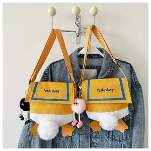 Detail of cute duck-themed canvas crossbody bag featuring plush tail and webbed feet decor
