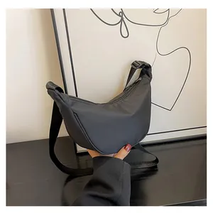 Dettaglio borsa a mezzaluna in nylon nero impermeabile con tracolla e fibbia regolabile