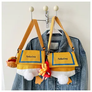 Detail of canvas crossbody bag featuring 3D duck tail and cute plush food charms
