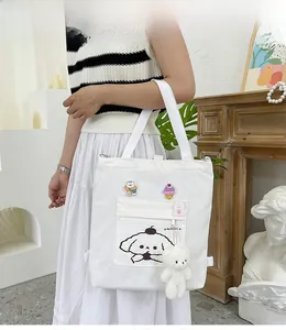 Vue détaillée du sac en toile blanche avec motifs de chiots et broderies d'ours