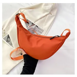 Vista dettagliata di una borsa a mezzaluna arancione in nylon con cerniera nera resistente