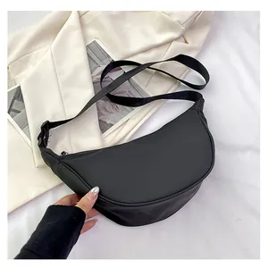Dettaglio borsa a tracolla nera in nylon a forma di mezzaluna con ampia cinghia regolabile
