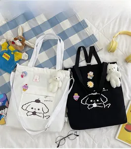 Vue à plat de sacs fourre-tout en toile avec imprimé cartoon et breloques ours noir et blanc