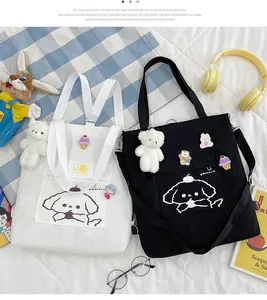 Détail de sacs en toile avec épingles de dessin animé, ours en peluche et logo yommy