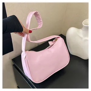Detailansicht der rosa Baguette-Tasche mit glatter Textur und goldenem Reißverschluss