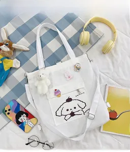 Détail du sac fourre-tout en toile blanche avec imprimé chien et badges de dessin animé