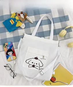 Détail d'un sac fourre-tout en toile blanche avec imprimé chien et bandoulière réglable