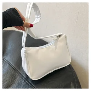 Detailansicht einer weißen Baguette-Tasche aus glattem Kunstleder mit Reißverschluss
