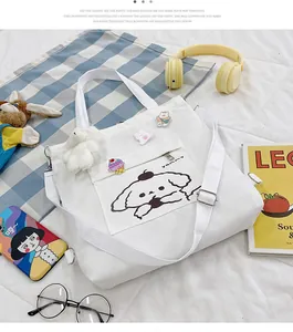 Détail du sac en toile blanche avec motif pompompurin et breloque ours en peluche