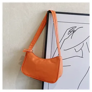 Detail einer leuchtend orangen Hobo-Tasche aus glänzendem Kunstleder mit Reißverschluss