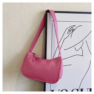 Detail der rosa Kunstleder-Baguette-Tasche an einem minimalistischen Wandrahmen