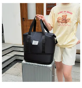 Detail of black waterproof travel bag with expansion layer on top of silver suitcase