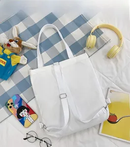 Détail du sac en toile blanche avec bandoulières polyvalentes et design minimaliste