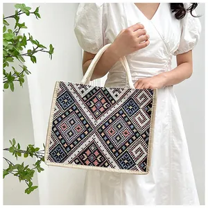 Dettaglio del ricamo etnico su una grande borsa tote in tela con manici intrecciati
