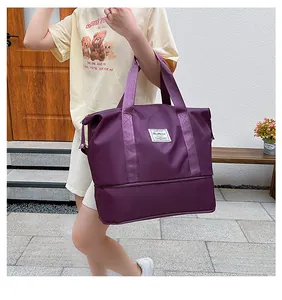 Detail of a large purple travel bag featuring a layered bottom and fashion fabric label