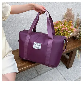 Close-up of a purple waterproof travel bag with bottom shoe compartment on a bench