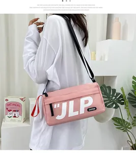 Detail of pink cylindrical nylon crossbody bag with JILPNG logo and red handle strap