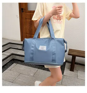 Detail of blue waterproof travel bag with a bottom shoe compartment and Fashion label