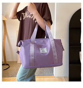 Detail of purple travel bag featuring a bottom zipper compartment and fashion label