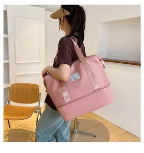 Detail of pink waterproof nylon travel bag with shoulder straps and bottom expansion layer