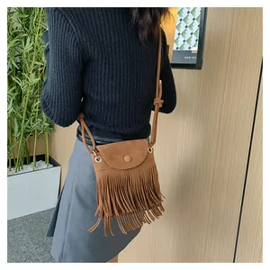 Gros plan sur le sac en daim marron avec franges bohèmes et rabat rond style vintage