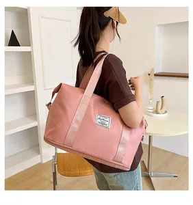 Pink waterproof travel bag shown with handle strap being carried for a fitness session