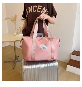 Close-up of pink waterproof travel bag with fashion label on silver suitcase