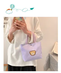 Close-up of light purple corduroy mini tote bag with a cute brown bear embroidery