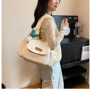 Off-white canvas tote bag with flap pocket and green cactus plush keychain detail