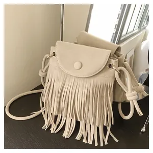Détail du sac bandoulière beige à franges avec texture en daim et design bohème chic