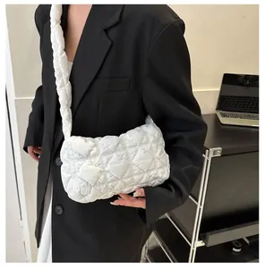 Dettaglio borsa a nuvola trapuntata in nylon bianco con ampia tracolla imbottita su blazer