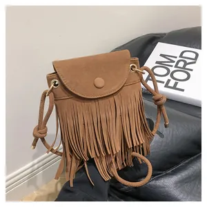 Détail du sac à bandoulière bohème en daim marron avec des franges décoratives