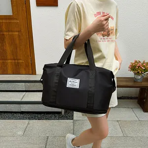 Black waterproof travel bag with double handles and bottom shoe compartment