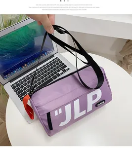 Detail of purple cylindrical messenger bag with white JLP lettering on a white table
