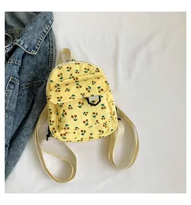 Detail view of mini corduroy backpack with cherry pattern on white fabric