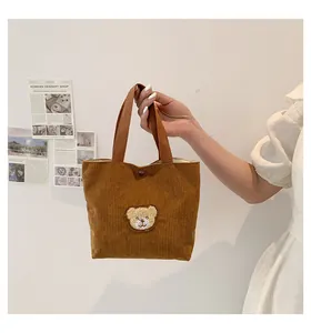 Detailed view of caramel corduroy mini handbag with cute plush bear and metal magnetic snap