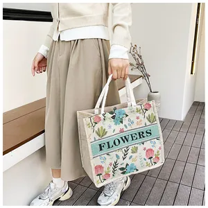 Detail of linen tote bag featuring floral print and flowers embroidery on fabric