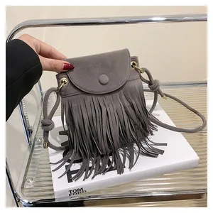 Détail du sac bandoulière gris en daim avec longues franges et boucle métallique chic