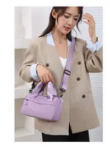 Dettaglio borsa a tracolla in nylon lilla con tracolla ampia su outfit casual