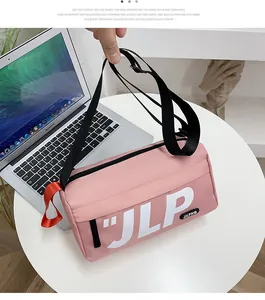 Detailed shot of pink cylindrical crossbody bag with JLP logo and orange accent strap