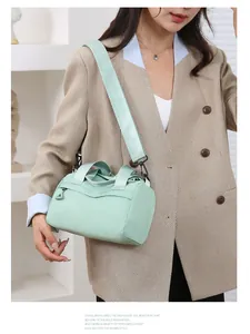 Dettaglio della borsa a tracolla in nylon verde chiaro con ampia tracolla e tasca con zip
