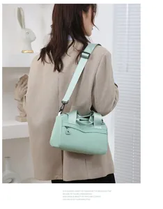 Borsa a tracolla in nylon verde chiaro con tracolla larga indossata da una modella