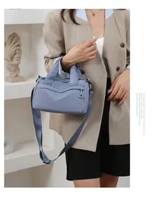 Borsa a tracolla in nylon azzurro con cuciture a V indossata su un outfit casual