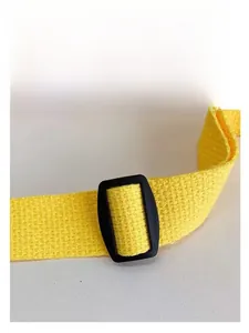 Détail de la sangle en nylon jaune avec boucle réglable en plastique noir pour sac enfant