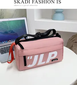 Detail of pink messenger bag showing durable nylon fabric and white JLP letter printing