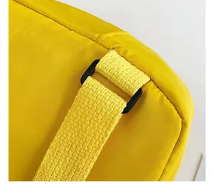Détail d'un sac jaune pour enfants en nylon avec couture propre et boucle en plastique